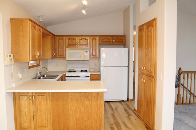 kitchen featuring kitchen peninsula, decorative backsplash, white appliances, sink, and lofted ceiling