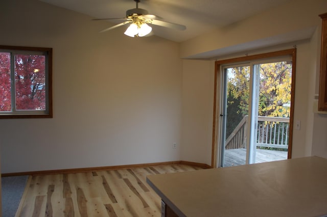 unfurnished dining area featuring light hardwood / wood-style floors, vaulted ceiling, and ceiling fan