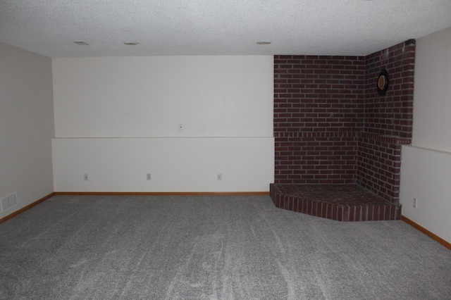 carpeted empty room featuring a textured ceiling