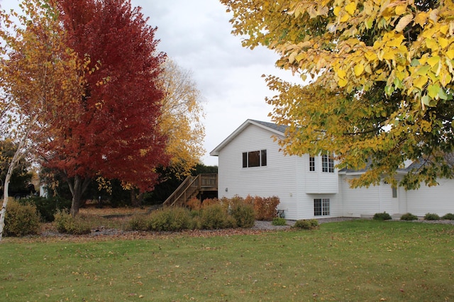 view of property exterior with a wooden deck and a lawn