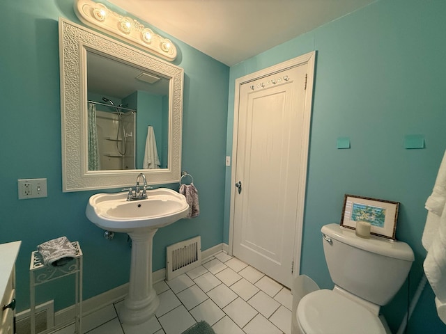 bathroom with tile patterned floors, toilet, and walk in shower