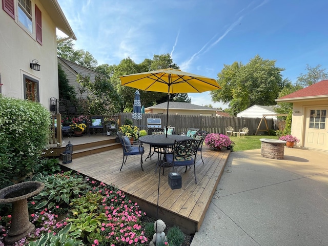 deck with grilling area, a patio area, and an outdoor fire pit