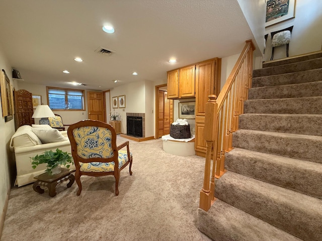 living room with light colored carpet and a tile fireplace