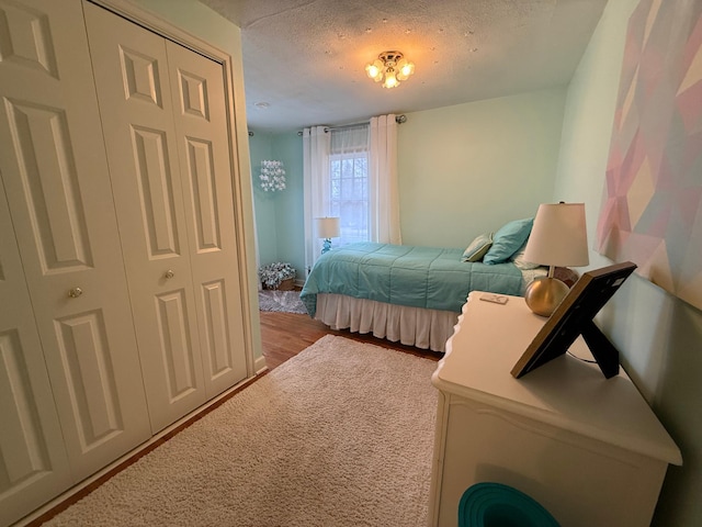 bedroom featuring hardwood / wood-style floors, a closet, and a textured ceiling