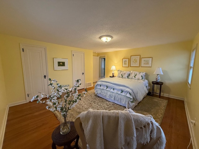 bedroom featuring dark hardwood / wood-style flooring and a textured ceiling