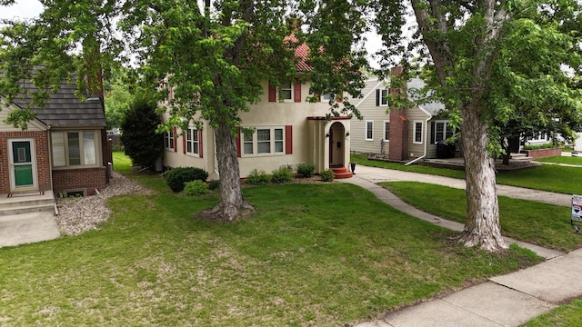 607 Lake Ave, Worthington, MN 56187 - townhome / multi-family property with brick siding, a front yard, entry steps, and stucco siding