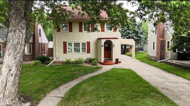 607 Lake Ave, Worthington, MN 56187 - view of front of house featuring stucco siding, a front lawn, and concrete driveway