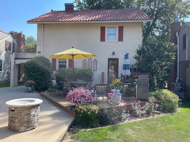 607 Lake Ave, Worthington, MN 56187 - mediterranean / spanish home with stucco siding, a wooden deck, a chimney, and a tiled roof