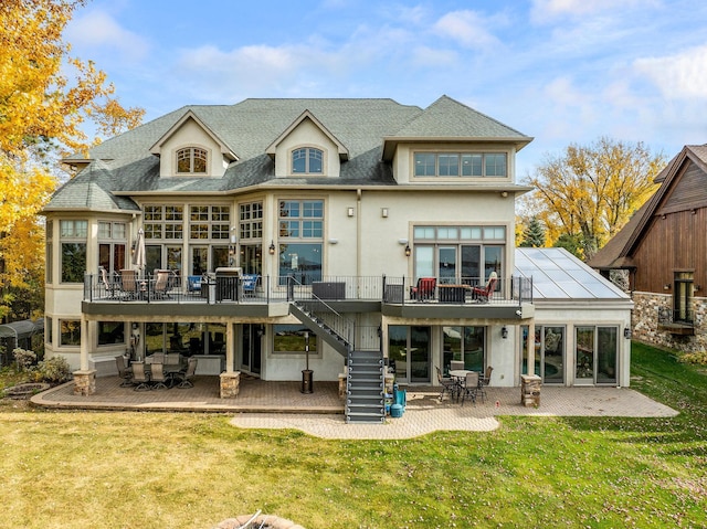 back of property with a patio, a lawn, and a wooden deck