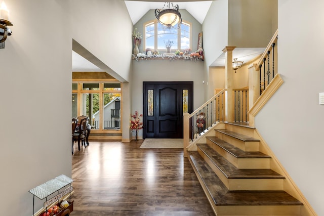 entrance foyer featuring ornate columns, high vaulted ceiling, and dark hardwood / wood-style floors