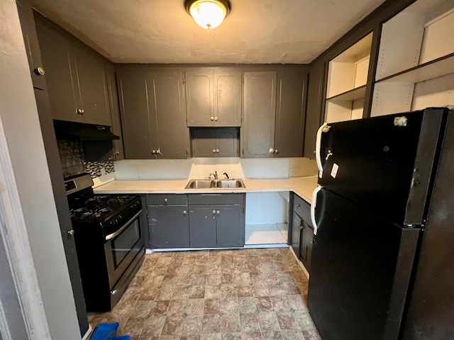 kitchen with black fridge, sink, tasteful backsplash, stainless steel range with gas cooktop, and gray cabinetry