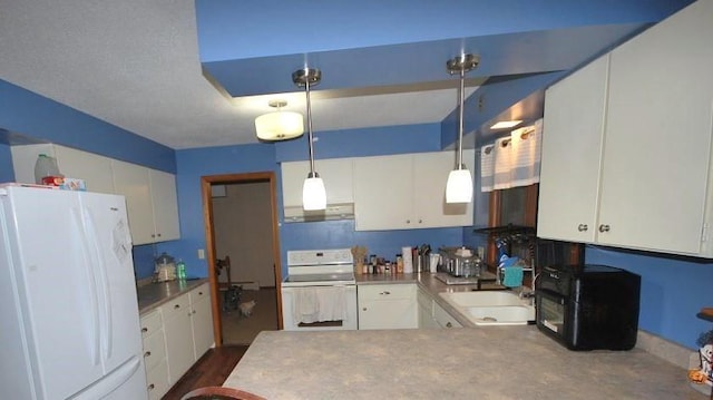 kitchen featuring white appliances, kitchen peninsula, pendant lighting, and white cabinets