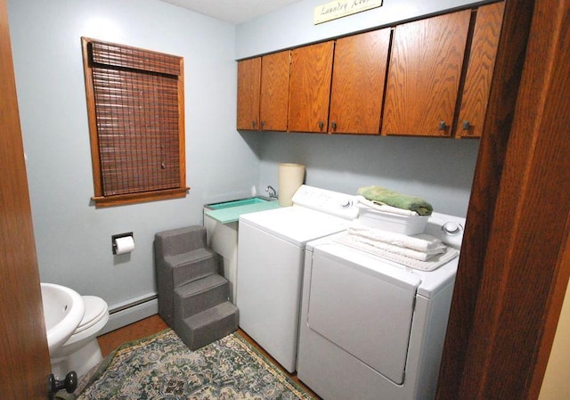 clothes washing area with a baseboard heating unit and separate washer and dryer