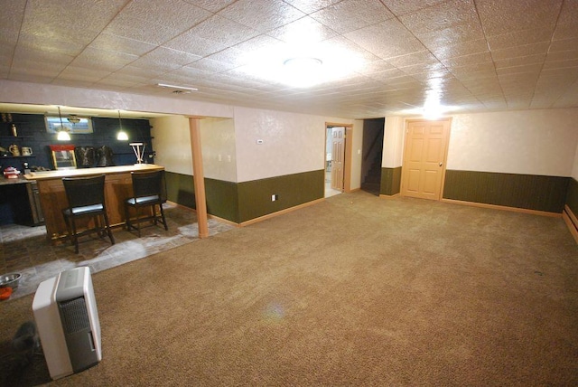 basement featuring carpet flooring and bar area