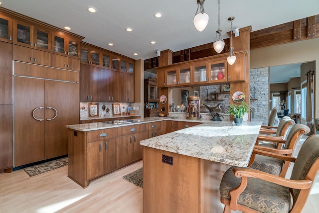 5441 Raven Point Rd, Spring Lake Twp, MN 55372 - kitchen featuring a peninsula, light wood finished floors, a kitchen breakfast bar, recessed lighting, and light stone countertops