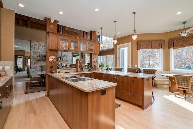 5441 Raven Point Rd, Spring Lake Twp, MN 55372 - kitchen featuring black electric stovetop, a peninsula, brown cabinetry, light wood-style flooring, and recessed lighting