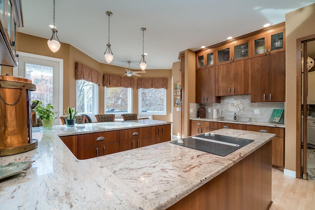 5441 Raven Point Rd, Spring Lake Twp, MN 55372 - kitchen with black electric cooktop, brown cabinets, light stone counters, decorative backsplash, and recessed lighting