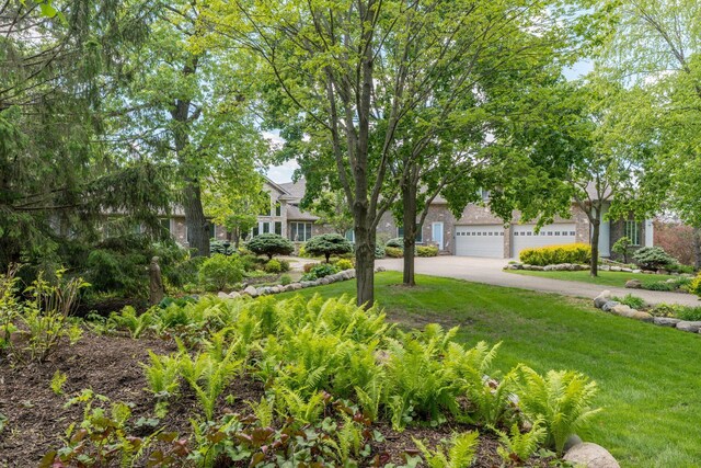 5441 Raven Point Rd, Spring Lake Twp, MN 55372 - view of property hidden behind natural elements featuring driveway, brick siding, a front yard, and a garage