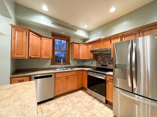 kitchen with appliances with stainless steel finishes, sink, and tasteful backsplash