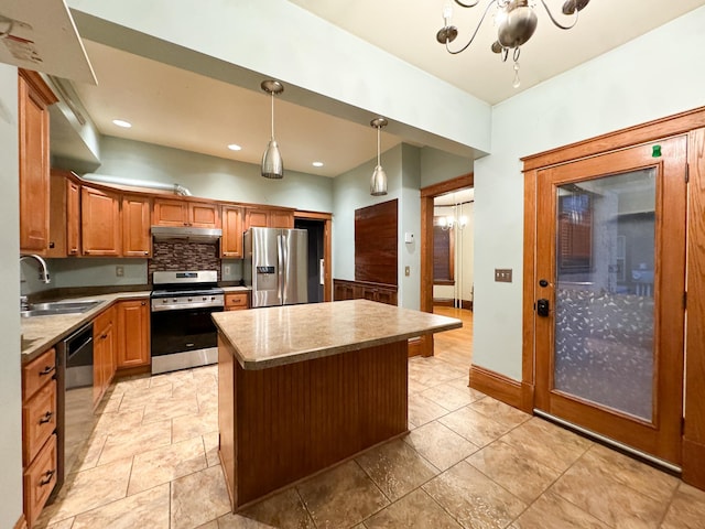 kitchen with stainless steel appliances, sink, backsplash, hanging light fixtures, and a kitchen island