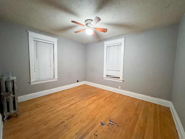 unfurnished room featuring wood-type flooring, ceiling fan, and a textured ceiling