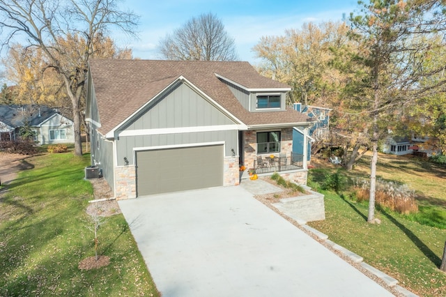 view of front of house featuring central AC, a garage, a porch, and a front yard