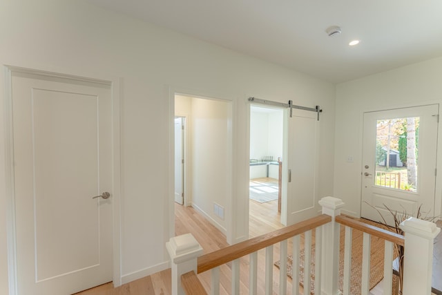 entryway featuring a barn door and light hardwood / wood-style floors