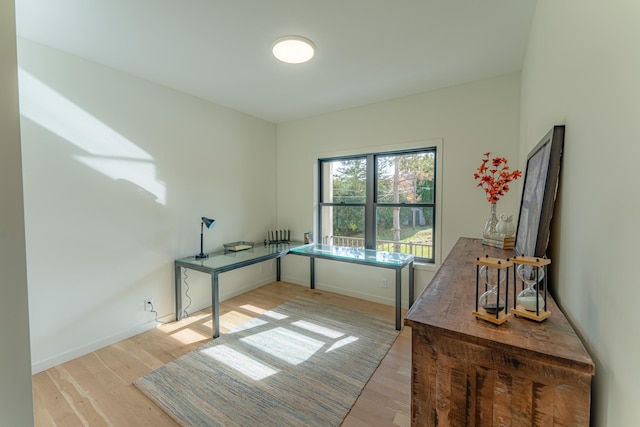 home office with light hardwood / wood-style floors