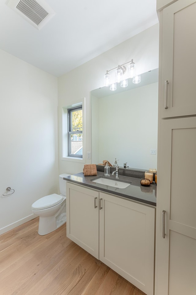 bathroom featuring toilet, vanity, and hardwood / wood-style flooring