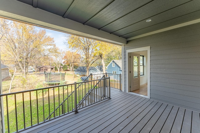 deck featuring a lawn and a trampoline