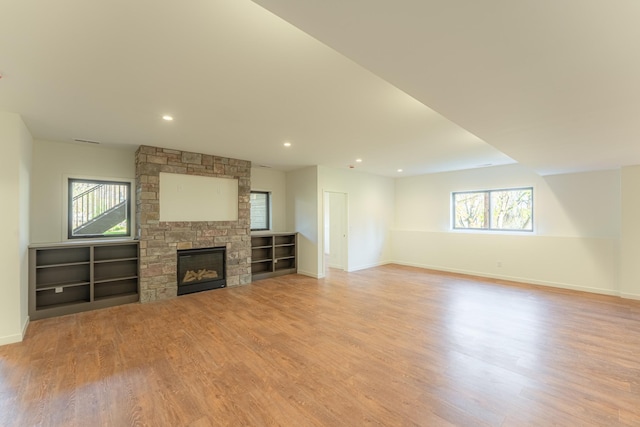 unfurnished living room with a fireplace, plenty of natural light, and light hardwood / wood-style flooring