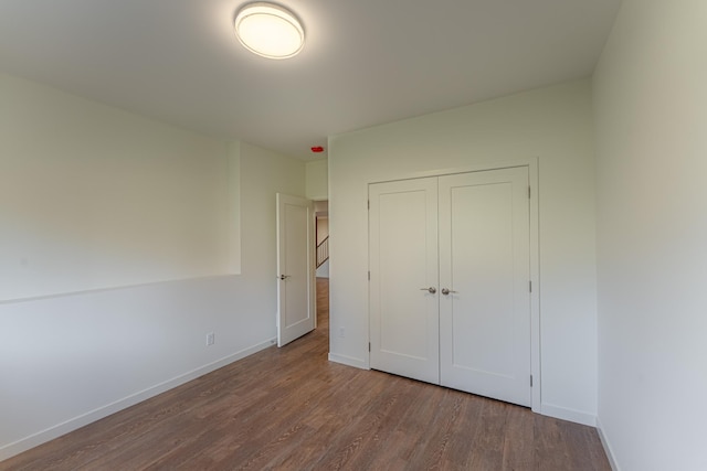 unfurnished bedroom with wood-type flooring and a closet