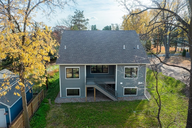 rear view of house featuring a yard and a deck