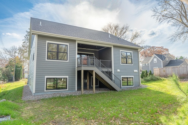 rear view of house featuring a deck and a lawn