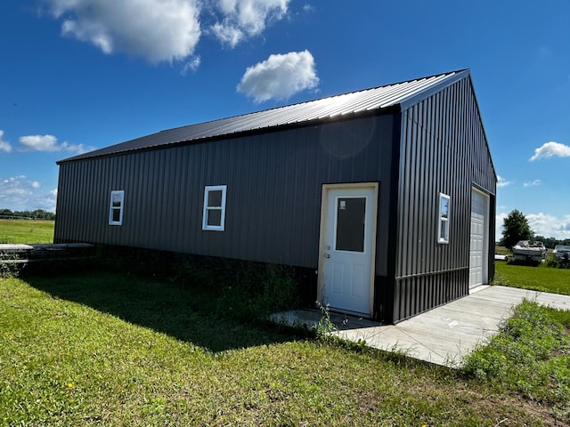 view of outbuilding featuring a garage and a lawn