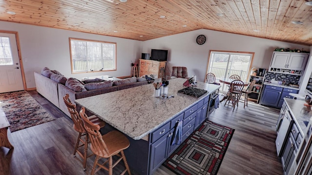 kitchen with vaulted ceiling, dark hardwood / wood-style floors, a breakfast bar area, blue cabinetry, and wooden ceiling