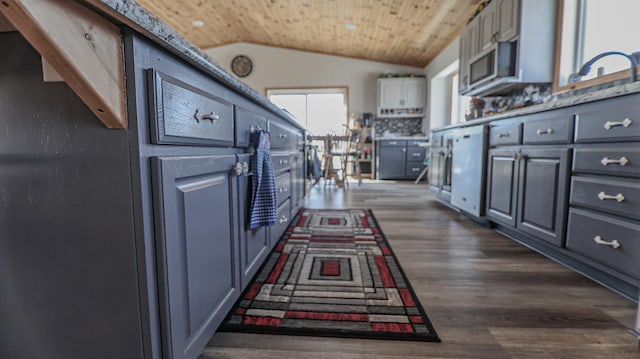 kitchen with vaulted ceiling, dark hardwood / wood-style floors, sink, gray cabinetry, and dishwashing machine