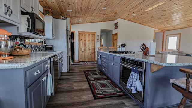 kitchen with sink, wooden ceiling, a kitchen island, stainless steel appliances, and white cabinets