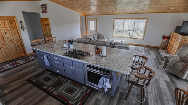 kitchen with wood ceiling, blue cabinetry, appliances with stainless steel finishes, and a kitchen bar