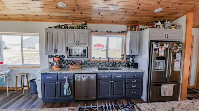 kitchen with sink, wood ceiling, light stone countertops, and appliances with stainless steel finishes