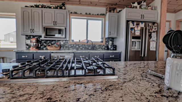 kitchen with appliances with stainless steel finishes, sink, and backsplash