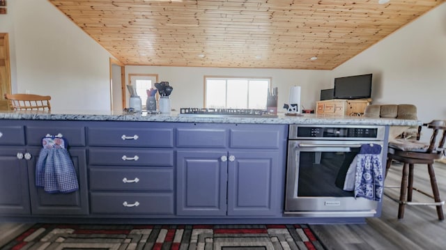 kitchen featuring blue cabinetry, vaulted ceiling, wooden ceiling, stainless steel appliances, and light stone countertops