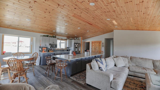 living room featuring vaulted ceiling, dark hardwood / wood-style floors, and wooden ceiling