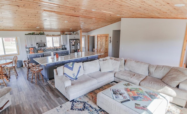 living room with lofted ceiling, hardwood / wood-style floors, wood ceiling, and sink