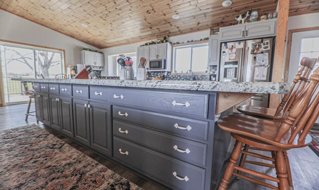 kitchen featuring wood ceiling, a breakfast bar, gray cabinetry, dark hardwood / wood-style flooring, and vaulted ceiling