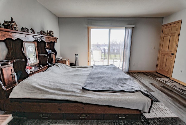 bedroom with hardwood / wood-style floors and access to outside