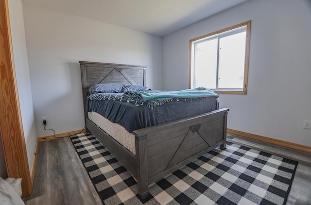 bedroom with dark hardwood / wood-style flooring