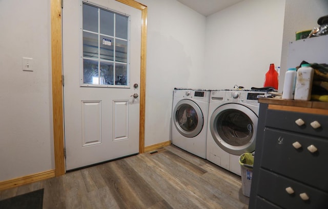 clothes washing area featuring hardwood / wood-style flooring and washer and clothes dryer