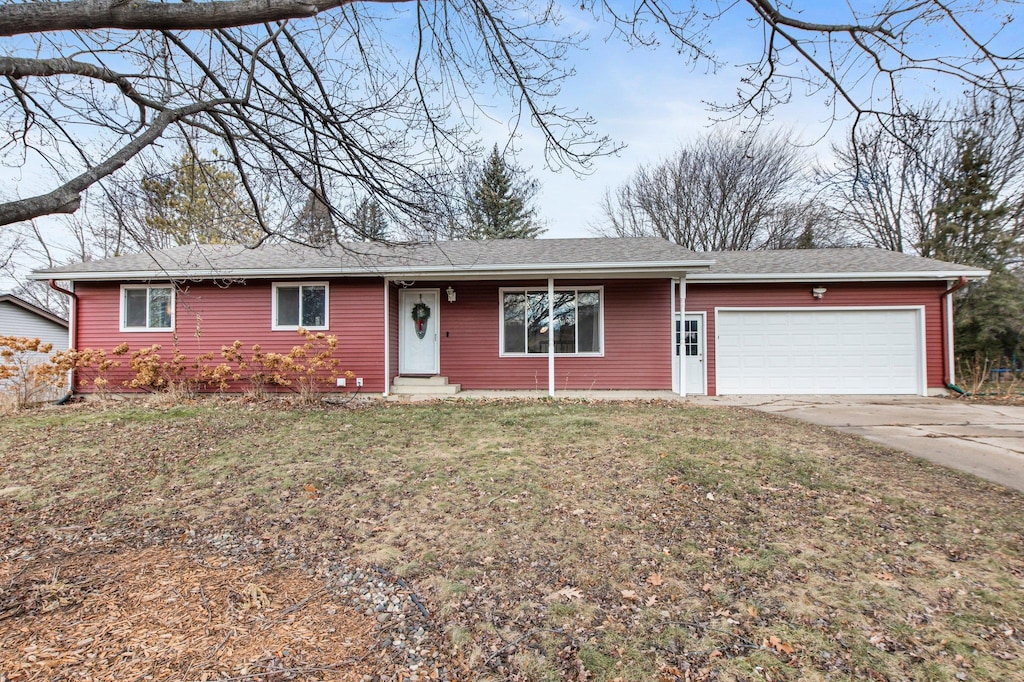 ranch-style home with a garage and a front yard