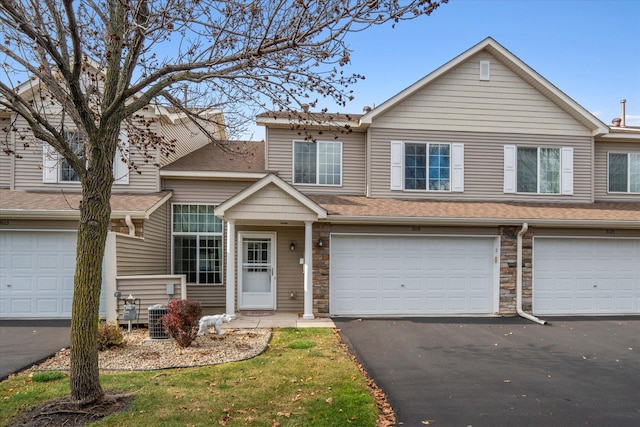 view of front of property with a garage and central AC